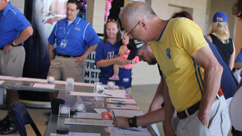 Fans mull over memorabilia Friday, May 25 during one of two in-game silent auctions held by the Drillers at ONEOK Field to raise money for Oklahoma Tornado Relief. The Drillers raised over $10,000 and donated another $10,000 to the American Red Cross.